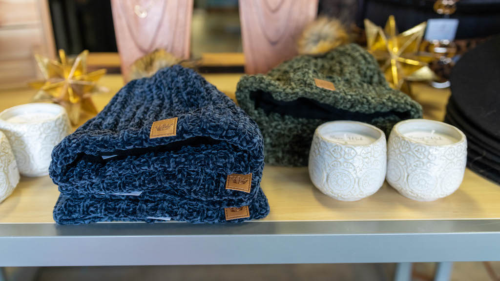 Knit hats and candles on display for shopping.