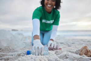 Volunteer reaching for a water bottle on the beach
